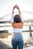 fille marchant sur la plage, contre le coucher du soleil photo