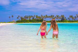 adorables petites filles à la plage pendant les vacances d'été photo