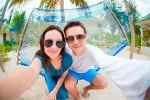 couple heureux faisant selfie relaxant dans un hamac photo