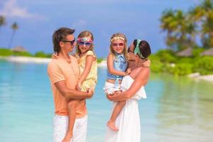 belle famille heureuse sur la plage blanche pendant les vacances d'été photo