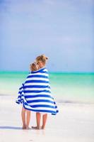 adorables petites filles enveloppées dans une serviette à la plage tropicale photo