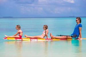 petites filles et jeune papa sur planche de surf pendant les vacances d'été photo