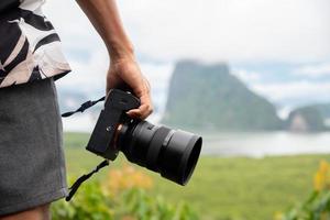 un touriste tenant un appareil photo vient à la mer, samet nangshe, phuket, thaïlande.