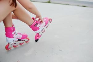 jeune femme mettant des rollers en plein air. photo