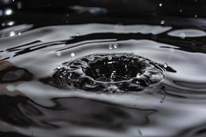 éclaboussures et vagues de gouttes d'eau tombant à la surface d'un liquide. photo