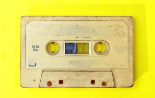 Vieille cassette rétro avec étiquette grunge sur fond jaune mise à plat photo