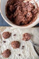 Évider la pâte à biscuits aux pépites de chocolat sur une plaque à biscuits en papier ciré mise à plat