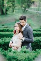 couple en tenue de mariage avec un bouquet de fleurs et de verdure est entre les mains sur fond de champ au coucher du soleil, la mariée et le marié photo