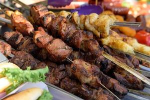 saucisse grillée avec ajout d'herbes et de légumes sur la plaque de gril, à l'extérieur. grillades, barbecue, barbecue photo