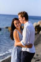 jeune beau couple s'embrassant sur fond de mer. photo