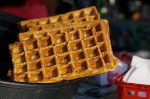 gros plan d'une gaufre traditionnelle rustique au festival de l'alimentation de rue. service de cuisine en plein air gastronomie et concept de plats à emporter photo