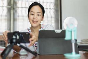 femme travaillant en ligne préparant la diffusion en direct au bureau à domicile. photo