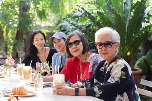 femme senior asiatique et fille adulte buvant du café au café en plein air. photo