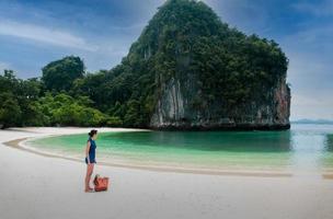 femme debout sur la plage regardant belle ocen dans l'île tropicale. photo