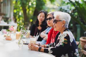 femme senior asiatique et fille adulte buvant du café au café en plein air. photo