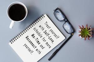 citation de motivation sur bloc-notes avec café et lunettes de lecture sur un bureau. photo