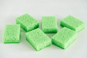 Éponges vertes pour le nettoyage sur fond blanc photo