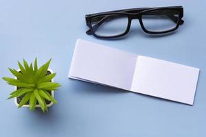 bloc-notes avec lunettes de lecture et plante en pot. concept de message et de rappel. photo