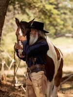 cowboy touche le cheval avec amour photo