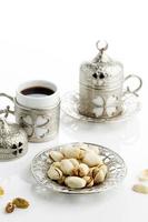 pistaches grillées servies avec du thé ou du café turc, sur fond blanc