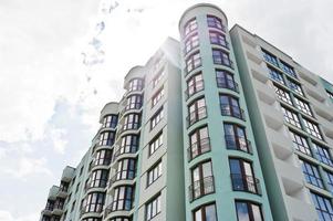 balcon de la nouvelle maison de construction résidentielle moderne de plusieurs étages turquoise dans un quartier résidentiel sur un ciel bleu ensoleillé.
