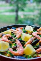 Close up paella de fruits de mer classique avec des moules, des crevettes et des légumes photo
