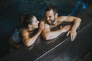 jeune couple se détendant dans une piscine photo