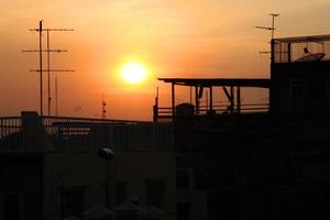 beau coucher de soleil coloré avec la silhouette des bâtiments de la ville. photo