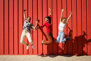 femmes multiethniques excitées sautant dans la rue photo