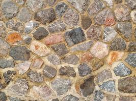 mur de roche de forme abstraite avec fond texturé de surface grunge de maçonnerie en béton. design pierre décorer la maison. photo