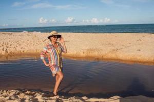femme portant des vêtements de plage colorés à la plage connue sous le nom de pitinga, à arraial d ajuda, bahia, brésil photo