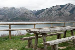 aire de pique-nique avec table et banc en bois. vue magnifique sur le réservoir d'eau de caldas de luna et les montagnes environnantes. Espagne photo