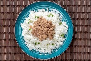 vue de dessus riz bouilli au thon dans une assiette verte