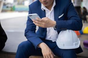 homme d'affaires passe le temps en utilisant un téléphone intelligent mobile en plein air. photo