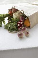 sac plein de légumes frais sur table, gros plan photo