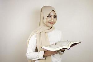 jeune femme musulmane asiatique souriante et tenant le coran photo