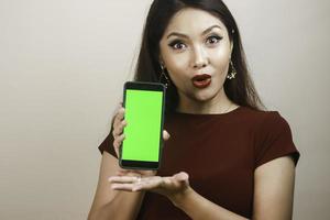 belle fille asiatique est choquée par le smartphone avec une chemise rouge photo