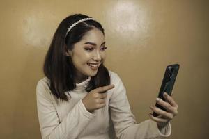 jeunes femmes asiatiques heureuses et souriantes au téléphone photo