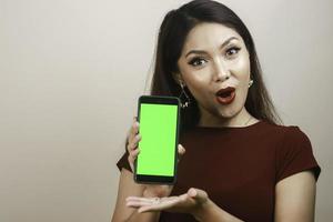 belle fille asiatique est choquée par le smartphone avec une chemise rouge photo