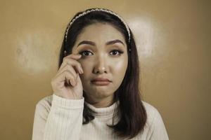 verser des larmes et triste expression d'une jeune femme asiatique en chemise blanche photo