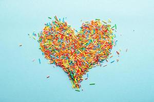 flatlay de concept simple avec un coeur fait de pépites de sucre colorées. photo