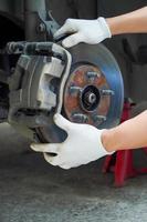 Mécanicien vérifiant les vieux disques de frein pour les voitures de garage photo