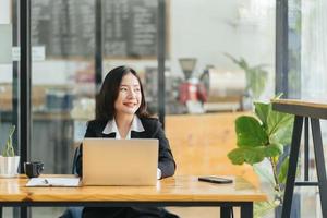 portrait d'une femme d'affaires décontractée heureuse en costume assise sur son lieu de travail au bureau photo