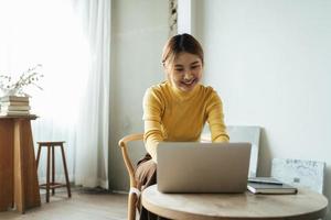 portrait d'une belle femme asiatique assise à l'intérieur au café-restaurant pendant l'été, à l'aide d'un ordinateur portable et d'un smartphone à technologie sans fil intelligente, pause-café relaxante au café-restaurant. photo