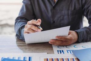 concept d'analyse de stratégie, homme d'affaires travaillant directeur financier recherchant la comptabilité de processus calculer analyser marché graphique données stock examen des informations sur la table au bureau. photo