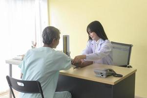 un patient masculin senior asiatique consulte et visite un médecin à l'hôpital. photo