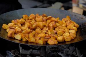 morceaux de pommes de terre frites dans une grande poêle pendant le festival de l'alimentation de rue. photo