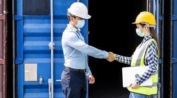 homme d'affaires et ingénieur femme se serrent la main comme bonjour dans le port de fret de conteneurs pour charger des conteneurs. serrer la main une fois l'inspection ou l'enquête terminée. industriel et commercial photo