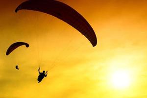 silhouette de parachute au coucher du soleil photo