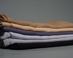 des piles de voiles de couleur nude soigneusement disposés sur un fond gris. mélange de tissu fin de couleur grise prêt à être utilisé pour les femmes musulmanes. peut également être utilisé pour les présentoirs de vente. flou de mise au point. hijab. photo